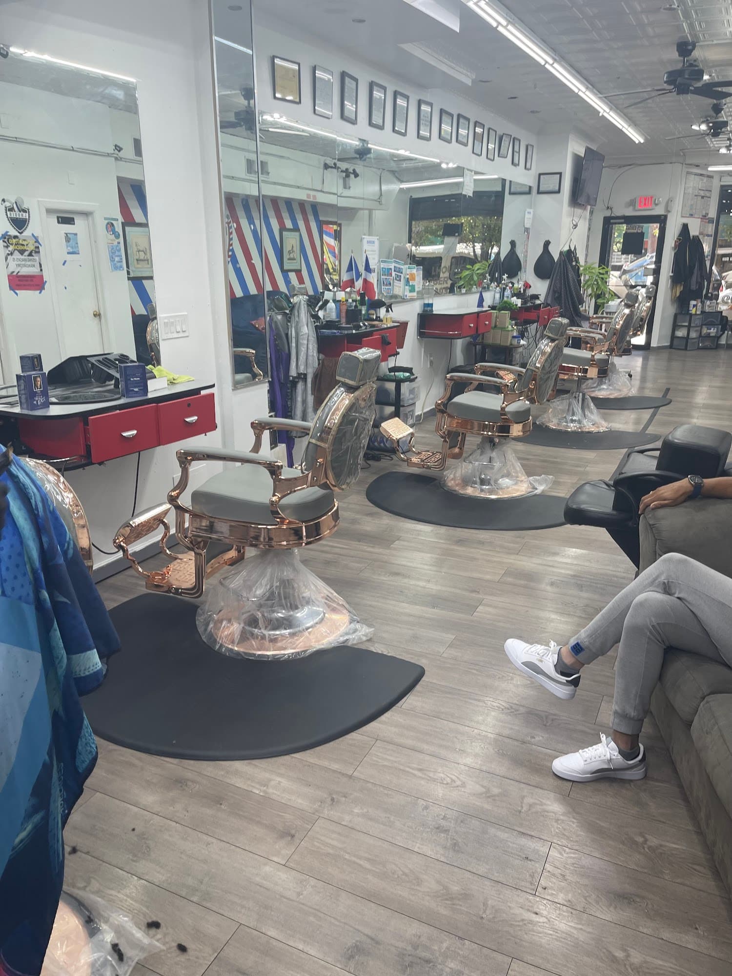 Long view of Lhouis Barber Shop floor, barber chairs, mirrors, and seating