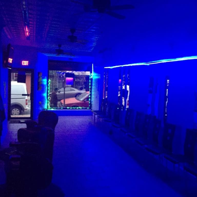 Lhouis Barber Shop at night with blue accent lighting along the ceiling